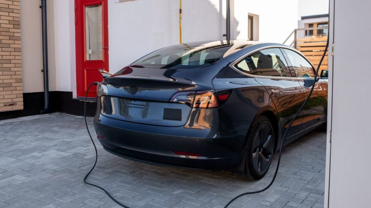 Black electric car is being charged at station