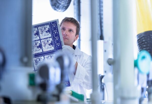 Worker inspecting circuit board by processing plant in circuit board factory Worker inspecting circuit board by processing plant in circuit board factory